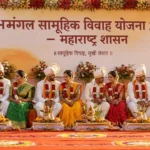 शुभमंगल सामूहिक विवाह योजना 2026 2 शुभमंगल सामूहिक विवाह योजनेंतर्गत महाराष्ट्रात आयोजित सामूहिक विवाह सोहळ्यात पारंपरिक वेशभूषेतील जोडपी मंचावर बसलेली असून पार्श्वभूमीवर महाराष्ट्र सरकारचा बॅनर दिसत आहे